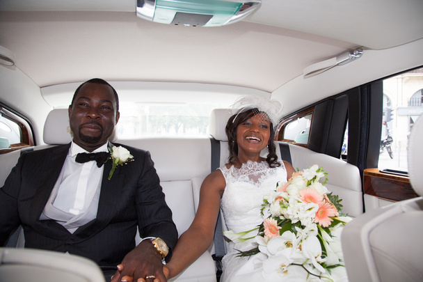Recién casada pareja africana sentada en el coche
 - Foto, imagen
