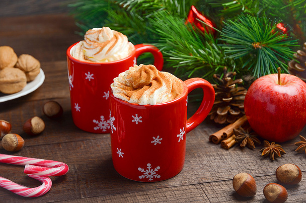Chocolat chaud avec crème fouettée dans des tasses rouges. Composition de Noël
. - Photo, image