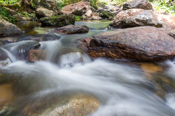 Vízesés lépcsőzetesen folyó alatt lapos sziklák az erdő. - Fotó, kép