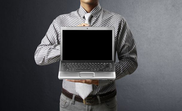 Hombre de negocios sosteniendo portátil
 - Foto, imagen