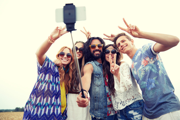 hippie friends with smartphone on selfie stick - Photo, Image