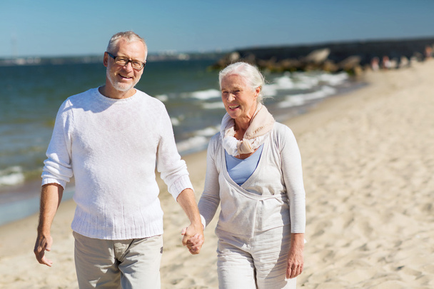 szczęśliwa para starszy trzymając się za ręce na lato plaża - Zdjęcie, obraz