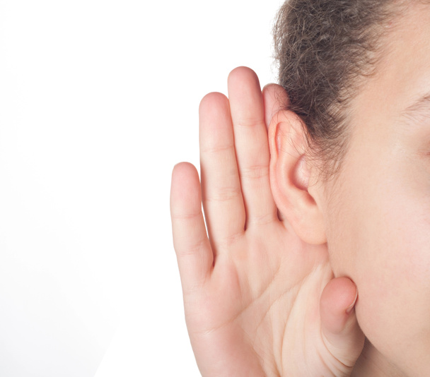 meisje met haar hand op een oor te luisteren - Foto, afbeelding
