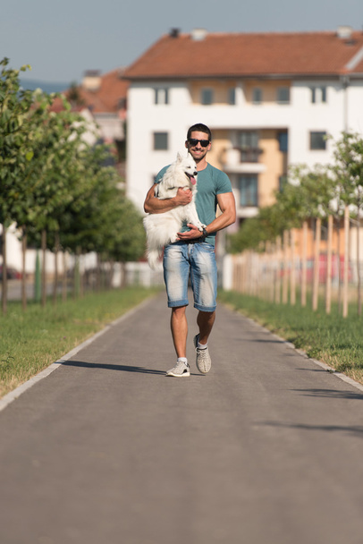 Young Man And Dog Walking On Park - Foto, imagen