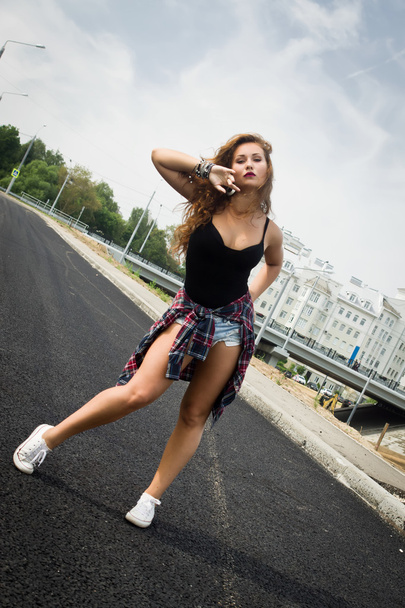 Молодая девушка танцует регетон на городской улице
 - Фото, изображение