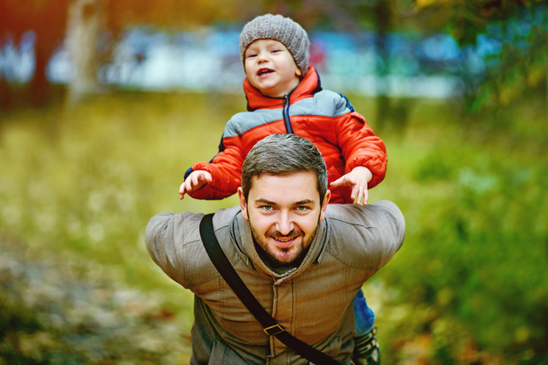 happy young father playing with son in autumn Park - Photo, Image