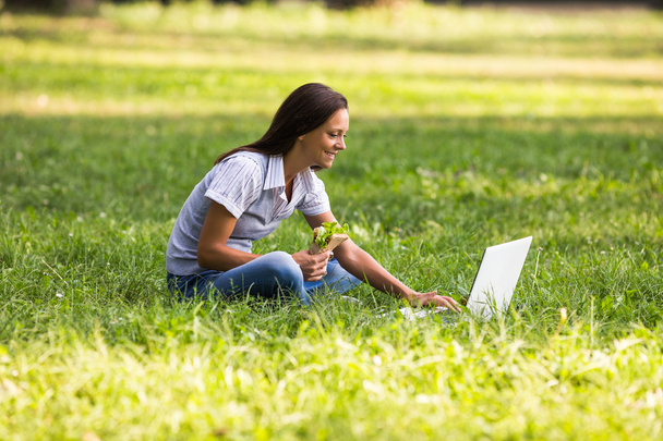businesswoman eating sandwich in park - Photo, Image