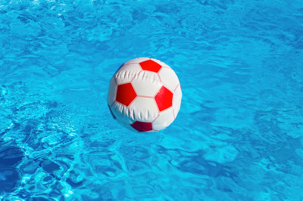 青いプールに浮かぶビーチボール - 写真・画像