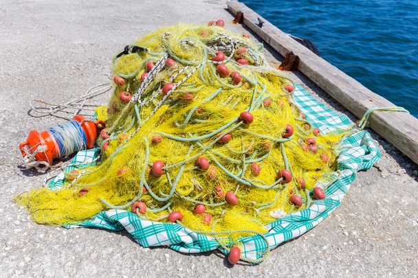 Montón de red de pesca amarilla en tierra en el mar
 - Foto, imagen