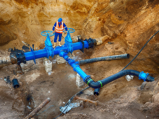 Worker underground at  gate valve on drink water system, waga multi joint members. - Photo, Image