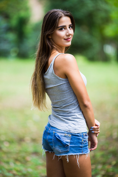 Beautiful young woman walking in summer park - Foto, Imagem