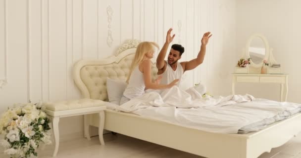 Couple Sitting bed dancing mix race man woman playing having fun together bedroom - Filmagem, Vídeo