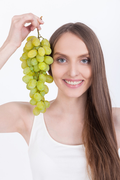 Chica sonriente en camiseta blanca con uvas
 - Foto, Imagen