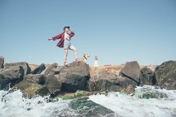 redhead girl with welsh corgi dog on the seaside - Zdjęcie, obraz