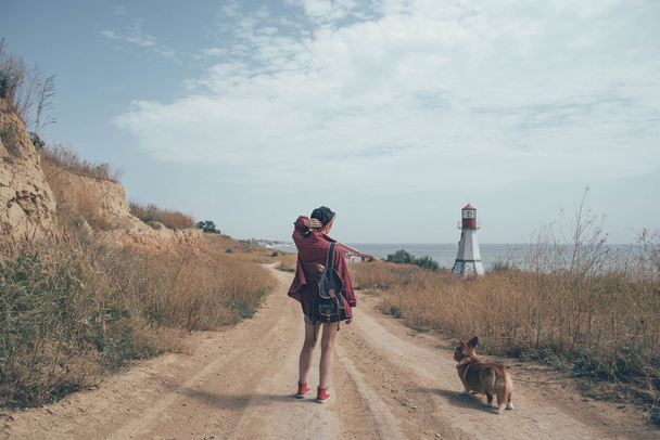 redhead girl with welsh corgi dog on the seaside - Zdjęcie, obraz