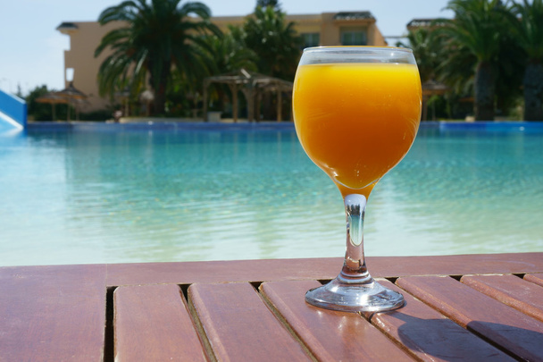 апельсиновый сок на фоне бассейна
 - Фото, изображение