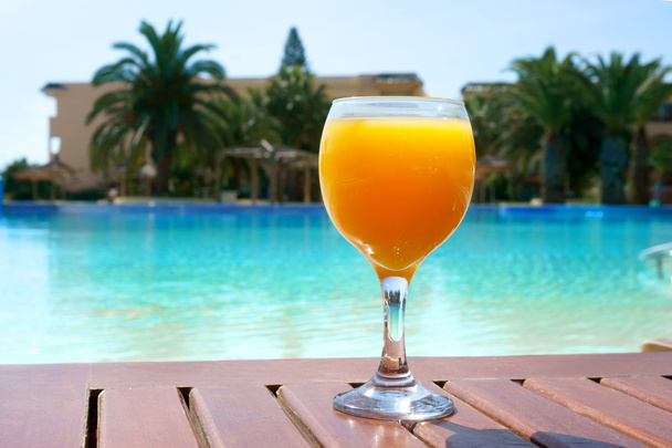 orange juice on a pool background - Foto, imagen