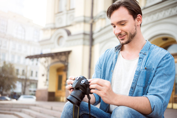 Handsome young man holding a camera - Photo, Image