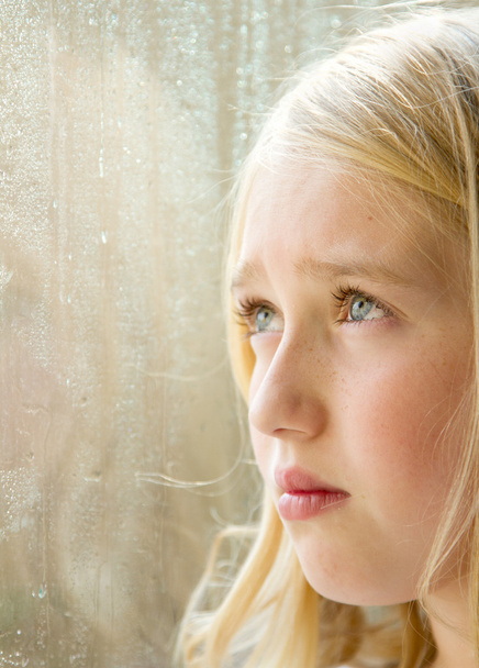 Close-up of a teen looking out a window - Photo, Image