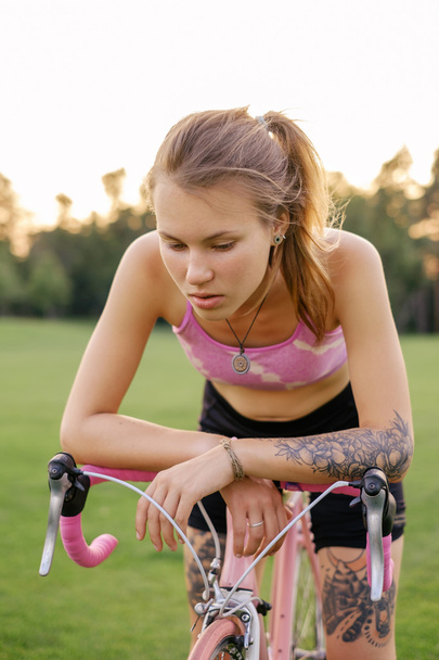 Retrato de mujeres jóvenes tatuadas con bicicleta
 - Foto, Imagen