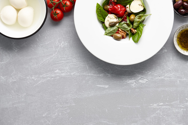 italienischer Salat mit Basilikum, Oliven und Mozzarella - Foto, Bild