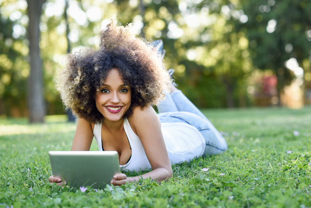 Tablet bilgisayar başında seyir afro saç modeli ile karışık kadın - Fotoğraf, Görsel