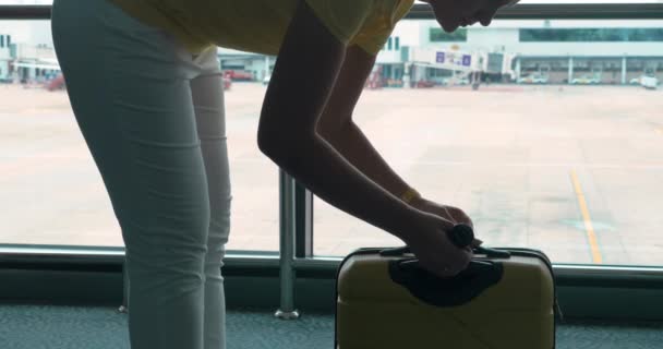 Kobieta waży jej bagażu przez Kompaktowe wagi w Lotnisko - Materiał filmowy, wideo