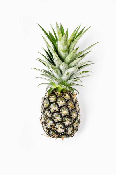 Top view of pineapples on wooden table over white background - Фото, изображение