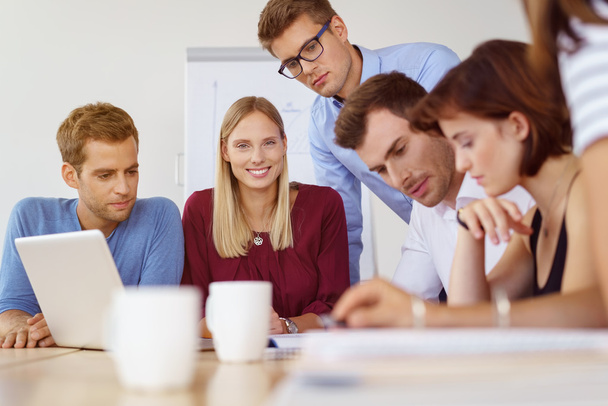 Happy woman with coworkers looking at report - 写真・画像