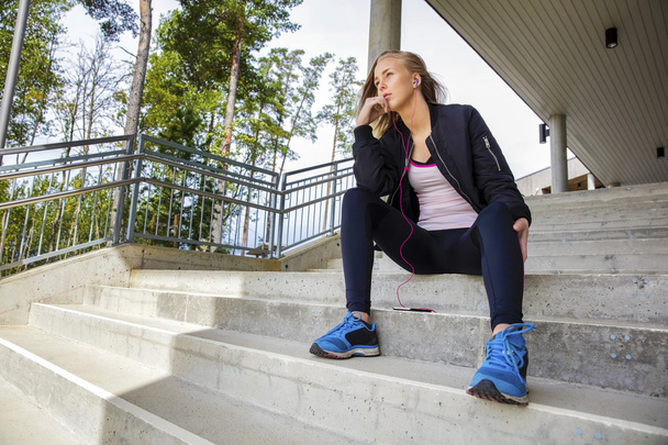 Thoughtful Young Woman In Sportswear Sitting On Steps - Фото, изображение