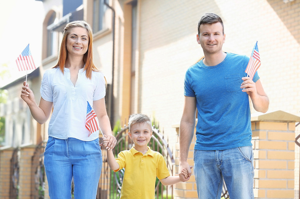 Happy family with little American flags in the yard - Photo, image