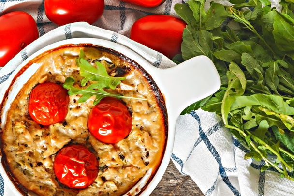 Casserole with zucchini, tomatoes and greens on a napkin on a wo - Zdjęcie, obraz