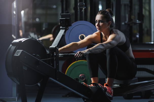 attractive muscular woman CrossFit trainer do workout on indoor rower - Foto, Imagem