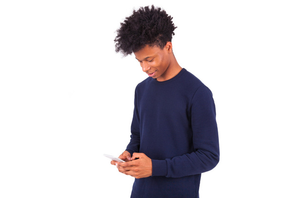 Young African American man sending a sms text message on his sma - Foto, imagen