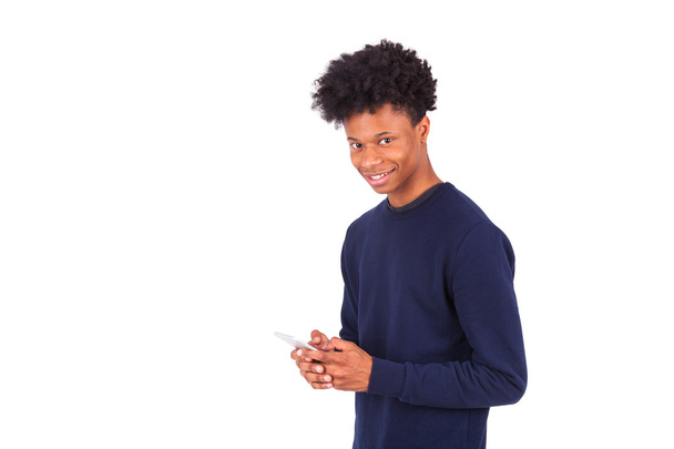 Young African American man sending a sms text message on his sma - Fotó, kép