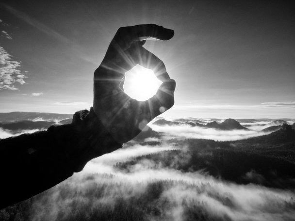 Man hand touch Sun. Misty daybreak in een prachtige heuvels.  - Foto, afbeelding