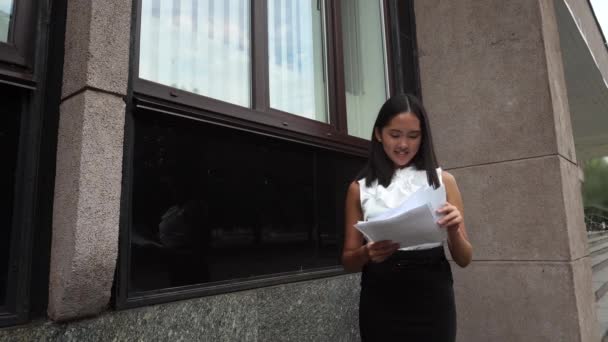 Fiatal gyönyörű üzleti nő női lány portré pillantást dokumentumok áll a háttérben irodaház szabadtéri - Felvétel, videó