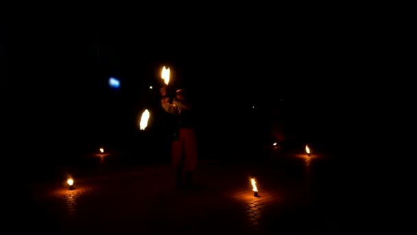Φωτιά εμφάνιση καλλιτέχνη αναπνέουν την πυρκαγιά στην παρουσίαση σκούρο επιδόσεις σε δράση στην διάρκεια της νύχτας. Φλεγόμενα μονοπάτια, καταπληκτικό - Πλάνα, βίντεο