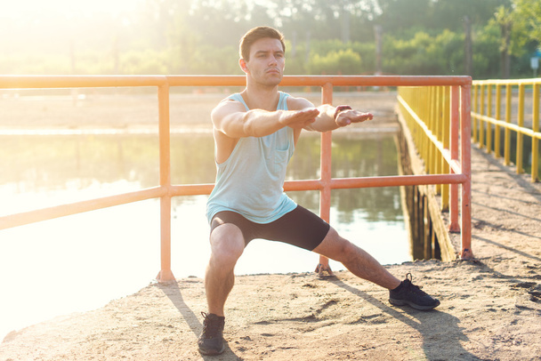 Fitnessmann Sportler wärmt Beine auf - Foto, Bild