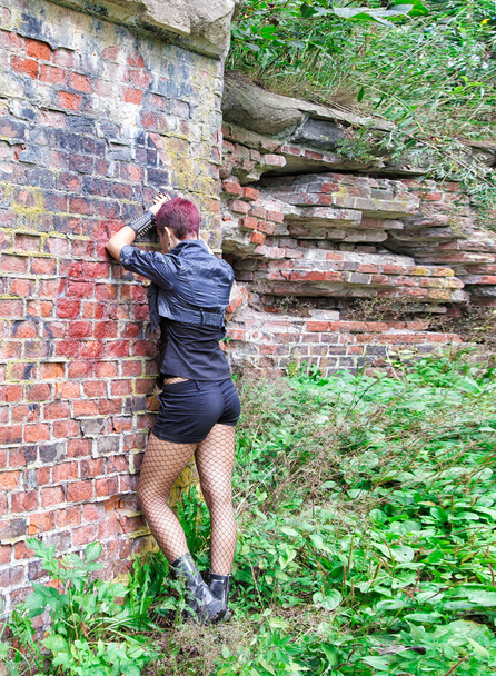 Punk meisje wordt aan de muur gedraaid - Foto, afbeelding