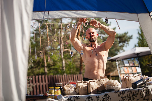 Bald muscular man selling handmade souvenirs at Avatar Yoga Festival - Foto, immagini