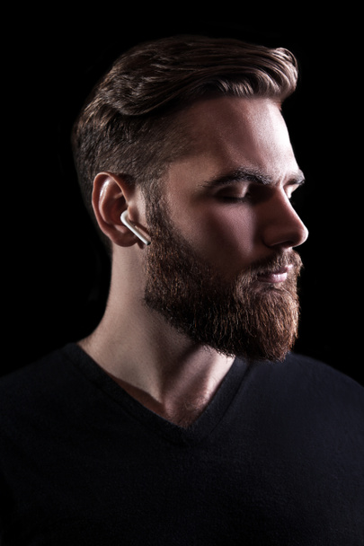 Young man with wireless earphone. - Foto, afbeelding
