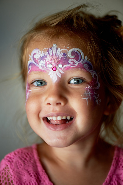 Pretty exciting blue-eyed girl of 2 years with a face painting - 写真・画像