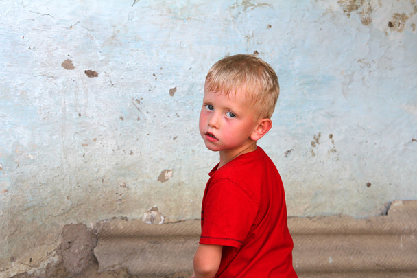 A fiú egy piszkos falhoz portréja - Fotó, kép