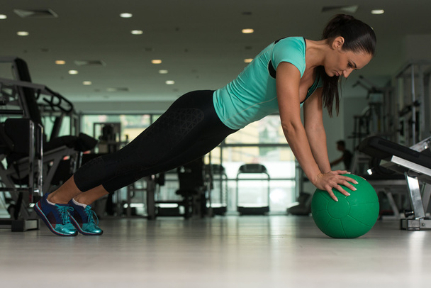 Attractive Woman Doing Push-ups On Floor In Gym - Foto, afbeelding