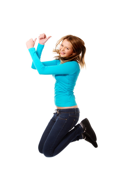Young woman jumping with thumbs up - Фото, зображення