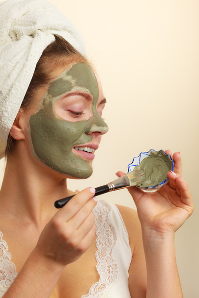 Woman applying with brush clay mud mask to her face  - Fotoğraf, Görsel