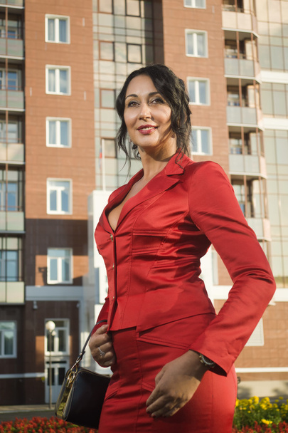 Atrakcyjny biznes dama w czerwonym kostiumie na ulicy - Zdjęcie, obraz