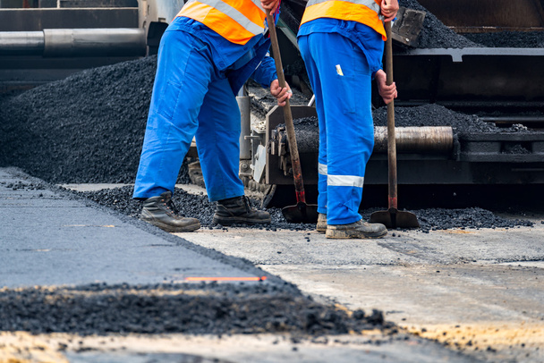 Los trabajadores y las máquinas de asfaltar
 - Foto, Imagen