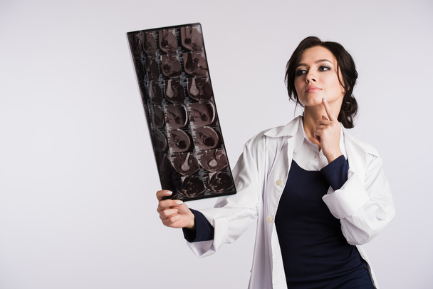 Женщина-врач смотрит на рентгеновские снимки
 - Фото, изображение